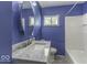 Updated bathroom features marble vanity, modern fixtures, and bright blue walls at 7702 Mary Ln, Indianapolis, IN 46217
