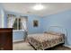 Bright blue bedroom with floral curtains, a white bed frame, and a patterned floral quilt at 8120 Glenwillow Ln # 206, Indianapolis, IN 46278
