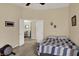 Cozy bedroom featuring a blue-and-gray quilt, a ceiling fan, and an open doorway to the adjacent room at 8120 Glenwillow Ln # 206, Indianapolis, IN 46278