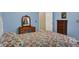 Comfortable bedroom featuring a floral bedspread, wooden furniture, and soft blue walls at 8120 Glenwillow Ln # 206, Indianapolis, IN 46278