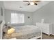 Bright bedroom featuring a ceiling fan, a white dresser, and a cozy bed with decorative pillows at 8120 Glenwillow Ln # 206, Indianapolis, IN 46278