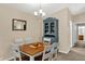 The dining room features a table, chairs, china cabinet, chandelier, and a mirror accenting the eating area at 8120 Glenwillow Ln # 206, Indianapolis, IN 46278