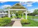 White gazebo with a picnic table set on a manicured lawn offers a relaxing community space at 8120 Glenwillow Ln # 206, Indianapolis, IN 46278