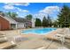 Spacious community pool with ample seating and a serene backdrop of lush trees and blue skies at 8120 Glenwillow Ln # 206, Indianapolis, IN 46278