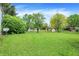 Expansive backyard with lush green grass, mature trees, and storage sheds at 831 Wakulla Ct, Indianapolis, IN 46217