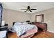 Simple bedroom with hardwood floors, patterned bedding, a ceiling fan, and wood dresser at 831 Wakulla Ct, Indianapolis, IN 46217