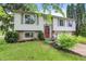 Charming home featuring light siding, a red front door, and a well-manicured front yard at 831 Wakulla Ct, Indianapolis, IN 46217