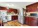 Well lit kitchen featuring stainless steel refrigerator, wooden floor and cabinets, and modern appliances at 831 Wakulla Ct, Indianapolis, IN 46217