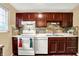 Full kitchen view showcasing wooden cabinets, modern white appliances, and neutral-toned tiled backsplash at 831 Wakulla Ct, Indianapolis, IN 46217