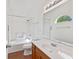 Bathroom featuring a tub, tile surround, wood cabinets, and a decorative window at 8451 Sunningdale Blvd, Indianapolis, IN 46234