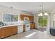 Well-lit kitchen with oak cabinets, white appliances, and a sliding glass door to the backyard at 8451 Sunningdale Blvd, Indianapolis, IN 46234
