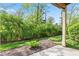 Back patio view with green landscaping and privacy shrubs at 8720 Yardley Ct # 100, Indianapolis, IN 46268