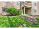 Back patio and lawn area with building overhang, green grass, and shrubs at 8720 Yardley Ct # 100, Indianapolis, IN 46268