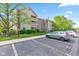 View of the building exterior, parking spaces, lawn, and trees on a sunny day at 8720 Yardley Ct # 100, Indianapolis, IN 46268