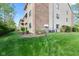 Exterior view of condo building featuring brick, siding, landscaping, and air conditioning units at 8720 Yardley Ct # 100, Indianapolis, IN 46268