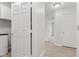 Hallway with laundry closet and view into other rooms showing light-colored floors and doors at 8720 Yardley Ct # 100, Indianapolis, IN 46268