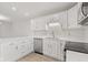 Galley kitchen boasts white cabinets, quartz countertops and stainless steel dishwasher and oven at 8720 Yardley Ct # 100, Indianapolis, IN 46268