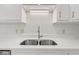 Quartz countertops and stainless steel double sinks with a silver faucet and bright under cabinet lighting at 8720 Yardley Ct # 100, Indianapolis, IN 46268