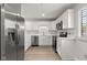 Galley kitchen boasts stainless appliances, white cabinets, quartz countertops and light wood flooring at 8720 Yardley Ct # 100, Indianapolis, IN 46268