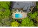 Aerial view of private backyard featuring in-ground pool, hot tub, patio seating, and mature trees at 9312 Sullivan Pl, Zionsville, IN 46077