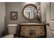 Cozy bathroom showcasing a unique vanity with floral accents, a round mirror, and a matching toilet at 9312 Sullivan Pl, Zionsville, IN 46077