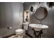 Stylish powder room featuring a vessel sink with decorative iron stand, complemented by gray walls and modern fixtures at 9312 Sullivan Pl, Zionsville, IN 46077
