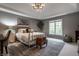 Cozy bedroom with a chandelier and large window, a brass bed, and neutral decor, creating a serene retreat at 9312 Sullivan Pl, Zionsville, IN 46077