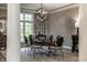 Formal dining area with an elegant chandelier, decorative columns, and a large window with natural light at 9312 Sullivan Pl, Zionsville, IN 46077
