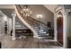 Elegant foyer with a curved staircase, hardwood floors, chandelier, and architectural columns at 9312 Sullivan Pl, Zionsville, IN 46077
