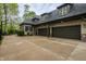 View of the side of the home featuring a driveway and attached garage with multiple doors and dormer windows at 9312 Sullivan Pl, Zionsville, IN 46077