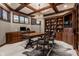 Elegant office with wood-paneled walls, coffered ceiling, a large desk, and custom built-in bookshelves at 9312 Sullivan Pl, Zionsville, IN 46077