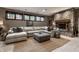 Inviting living room featuring a stone fireplace, large sectional sofa, and plush ottoman for relaxation at 9312 Sullivan Pl, Zionsville, IN 46077