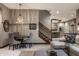 Open-concept living area with modern chandelier, staircase, and a glimpse of the open kitchen at 9312 Sullivan Pl, Zionsville, IN 46077