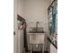 Functional utility sink area with stainless steel sink, cactus art, and convenient wall-mounted storage at 9312 Sullivan Pl, Zionsville, IN 46077
