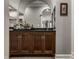 A stylish bar area featuring dark wood cabinets, a black countertop, and a sink with a decorative mirror at 9312 Sullivan Pl, Zionsville, IN 46077
