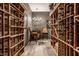 Elegant wine cellar with custom racking, tiled flooring, and a charming seating area at 9312 Sullivan Pl, Zionsville, IN 46077
