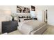 Modern bedroom boasts neutral tones, stylish abstract art, and a view of a large luxurious bathroom at 9386 Abner St, McCordsville, IN 46055