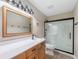 Bright bathroom featuring a wooden vanity with white countertop and a sleek glass-enclosed shower at 9454 W Canoe Trl, Pendleton, IN 46064