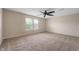 Generous main bedroom with plush carpeting, a ceiling fan, and multiple windows for natural light at 9454 W Canoe Trl, Pendleton, IN 46064
