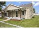Quaint stone-clad home boasts a charming front porch with a well-kept lawn and walkway at 997 Yandes St, Franklin, IN 46131