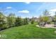 A well-manicured backyard featuring a patio with outdoor seating and lounge chairs, surrounded by trees and landscaping at 1013 Domino Dr, Carmel, IN 46032