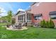 Landscaped backyard features patio seating, lush green grass, and screened in porch at 1013 Domino Dr, Carmel, IN 46032