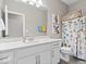 Well-lit bathroom featuring a vanity with a white marble top and colorful shower curtain at 1013 Domino Dr, Carmel, IN 46032