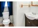 A bathroom with a small sink, toilet, and dark-blue curtains in front of the window at 1020 E Sixth St, Greenfield, IN 46140