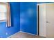 A bedroom painted a deep blue, features a window and a white closet door at 1020 E Sixth St, Greenfield, IN 46140