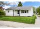 A well-maintained single-story home with white siding, green lawn, and mature trees in a quiet neighborhood at 1020 E Sixth St, Greenfield, IN 46140