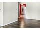 Open-concept living space with hardwood floors and a view into the kitchen with bright red walls and light wood cabinets at 1020 E Sixth St, Greenfield, IN 46140