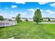 Scenic backyard with well-kept lawn, wooden deck, and a peaceful pond view, ideal for relaxation at 10828 Young Lake Dr, Indianapolis, IN 46229