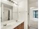 Bright bathroom featuring double sinks, a large mirror, and doorway to a bedroom at 10828 Young Lake Dr, Indianapolis, IN 46229