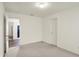 Neutral bedroom with light carpeting, offering doorway access to kitchen and hallway at 10828 Young Lake Dr, Indianapolis, IN 46229